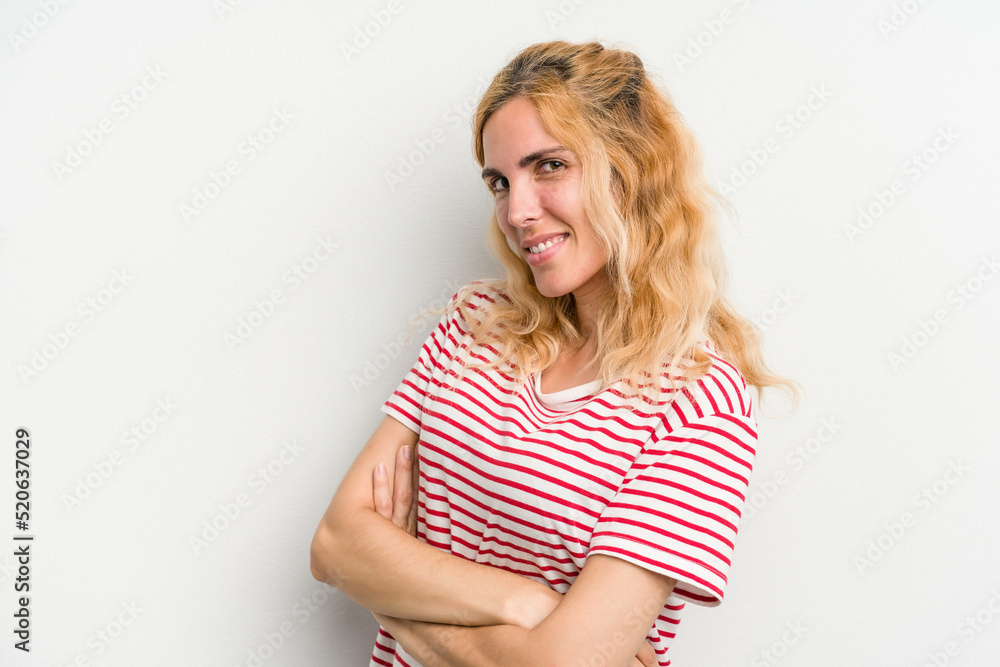Young caucasian woman isolated on white background who feels confident, crossing arms with determination. Young caucasian woman isolated on white background who feels confident, crossing arms with determination.