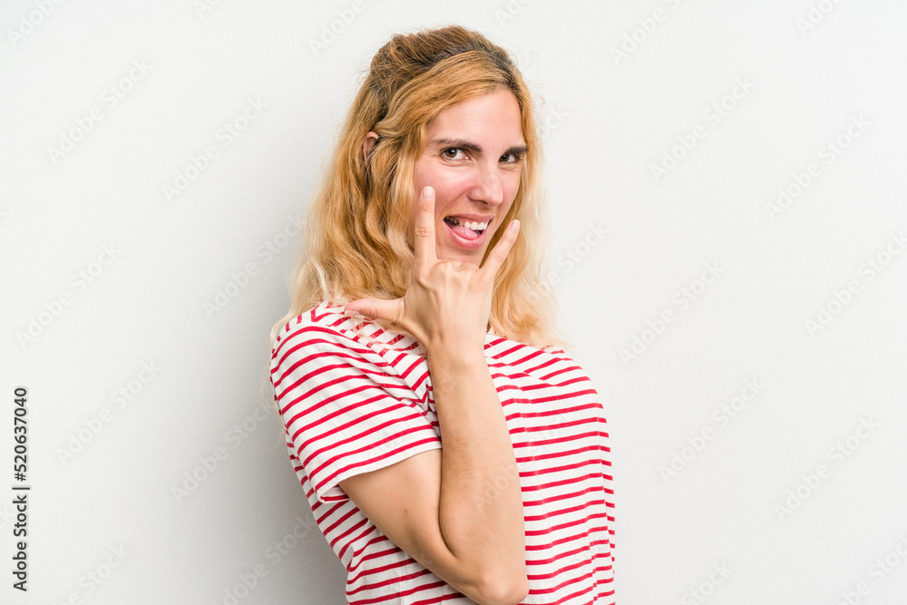 Young caucasian woman isolated on white background showing rock gesture with fingers Young caucasian woman isolated on white background showing rock gesture with fingers