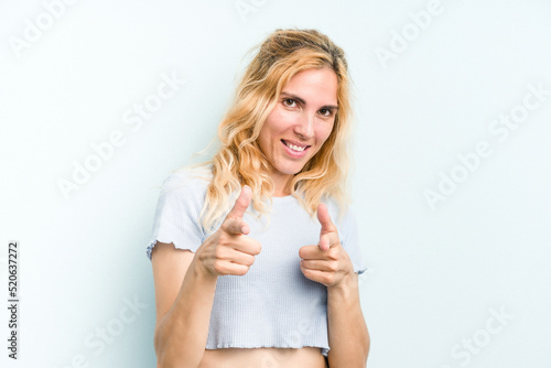 Young caucasian woman isolated on blue background pointing to front with fingers.