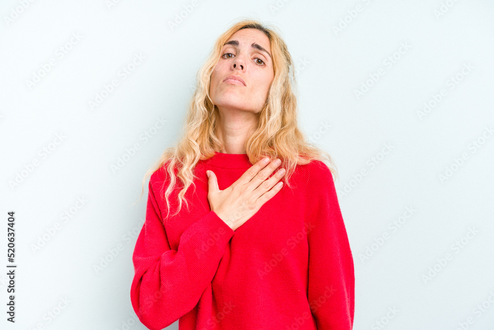 Young caucasian woman isolated on blue background taking an oath, putting hand on chest. Young caucasian woman isolated on blue background taking an oath, putting hand on chest.