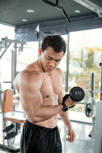Asian men exercise by lifting weights or lifting dumbbells. Asian bodybuilder fitness concept