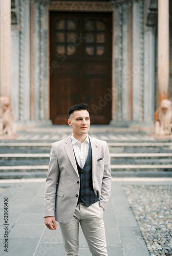 Man in a suit stands in front of the door to the church. Bergamo, Italy © Nadtochiy
