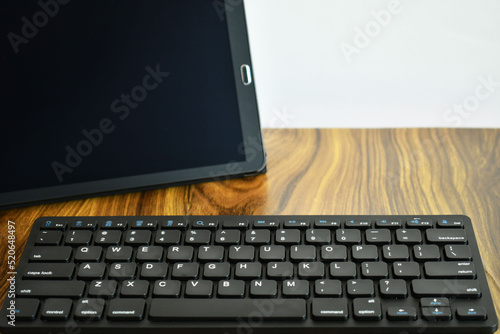 Tableta y teclado inalambrico sobre un escritorio de trabajo. photo