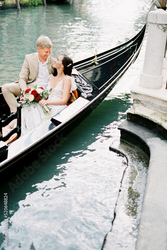 Bride and groom ride a gondola in Venice