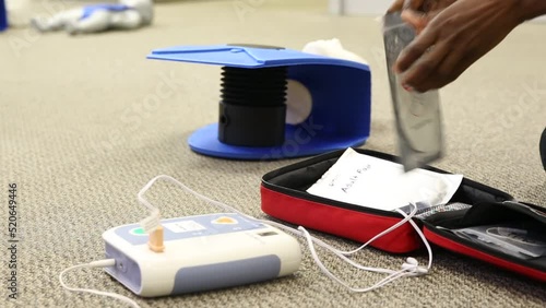 Staff practicing first aid cpr with AED machine and dummy dolls