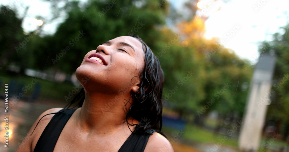 Woman standing outside in pouring rains hower, happiness concept Woman standing outside in pouring rains hower, happiness concept