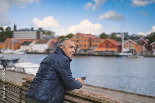 attractive old man walking in the city  lifestyle portrait with Tonsberg viewpoint
