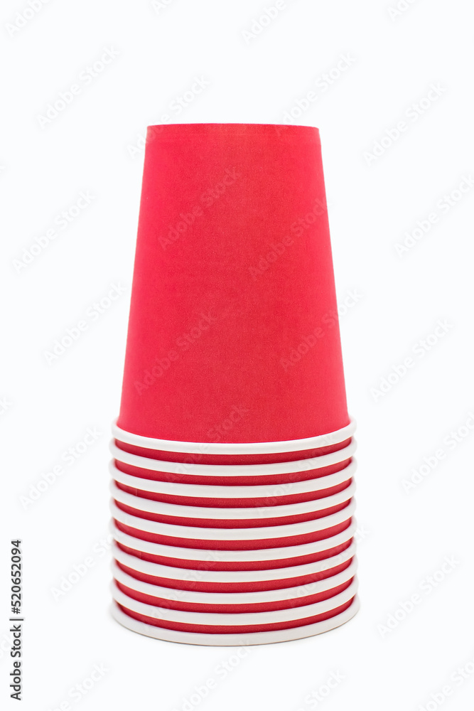 Red disposable cardboard cups stacked in a pile on a white background. Lots of disposable cups stacked one on top of the other and ready to make coffee or drinks Red disposable cardboard cups stacked in a pile on a white background. Lots of disposable cups stacked one on top of the other and ready to make coffee or drinks