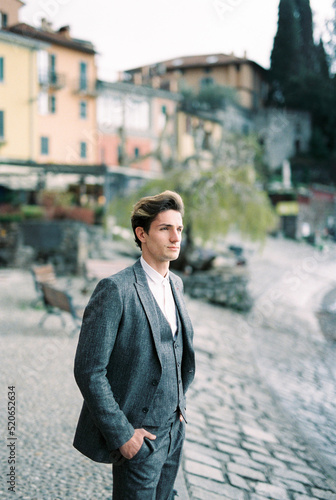 Man in a suit stands on the embankment of Varenna. Italy © Nadtochiy