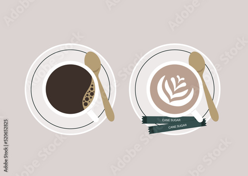 A top view of two cups of coffee, black and cappuccino, served on saucers with cane sugar packets