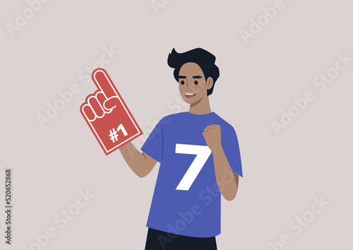 A young male Caucasian team supporter waving a foam finger, sports competition