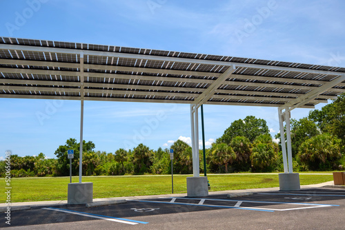 Solar panels installed over parking lot canopy shade for parked cars for effective generation of clean energy photo