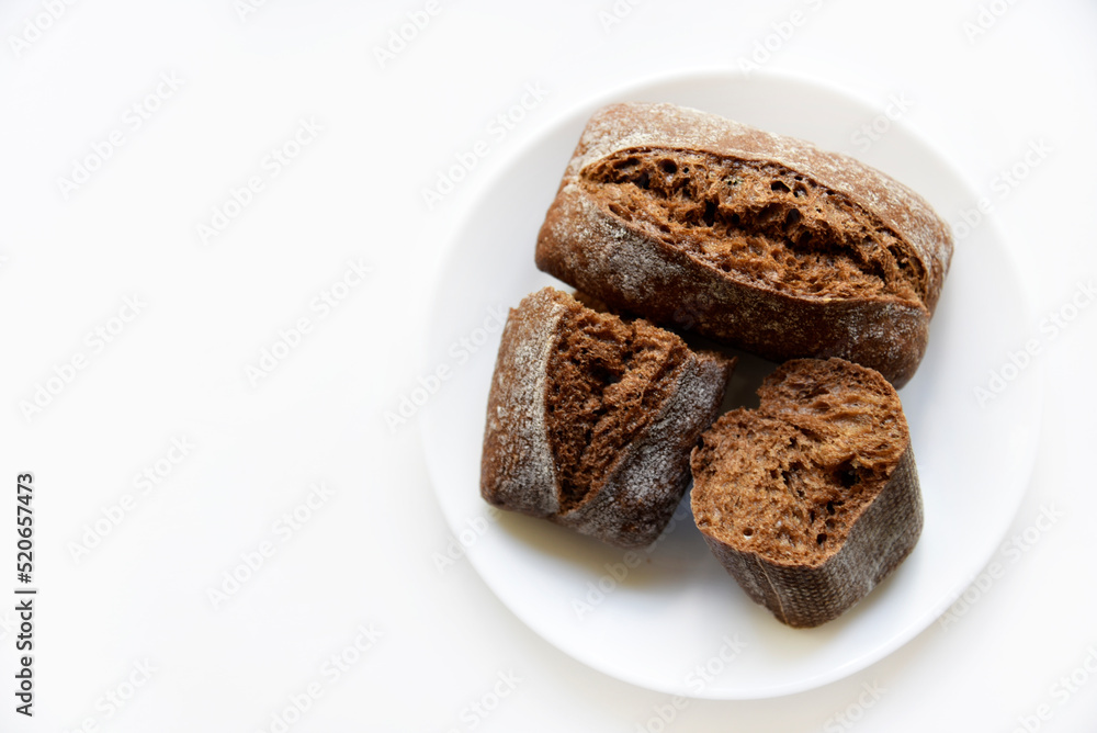 Rye bread from a hypermarket on a white plate. Delicious and beautiful bread macrophoto. Rye bread from a hypermarket on a white plate. Delicious and beautiful bread macrophoto.