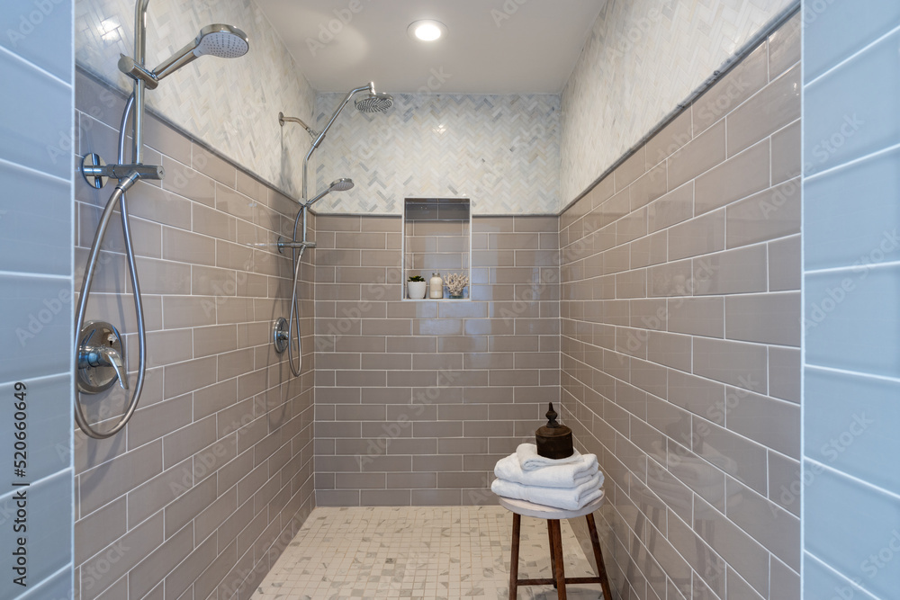 Walk in shower with double shower heads and multiple tile patterns