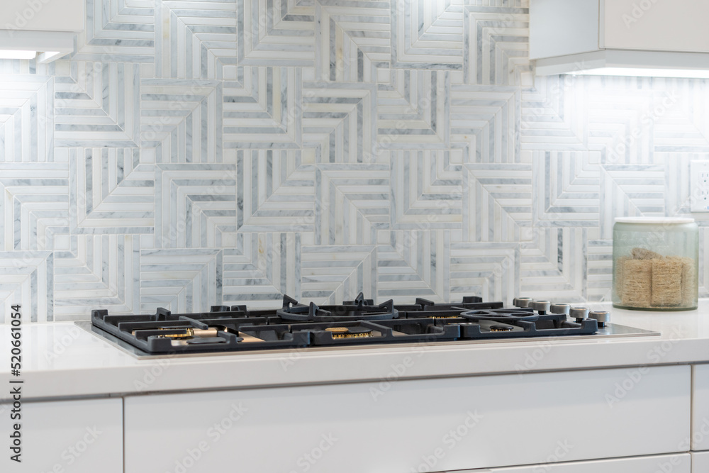 Modern kitchen details of flat top stove with pattern tile backsplash. Modern kitchen details of flat top stove with pattern tile backsplash.
