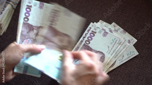 Female hans counting ukraininan hryvna  banknotes nominated 1000. photo