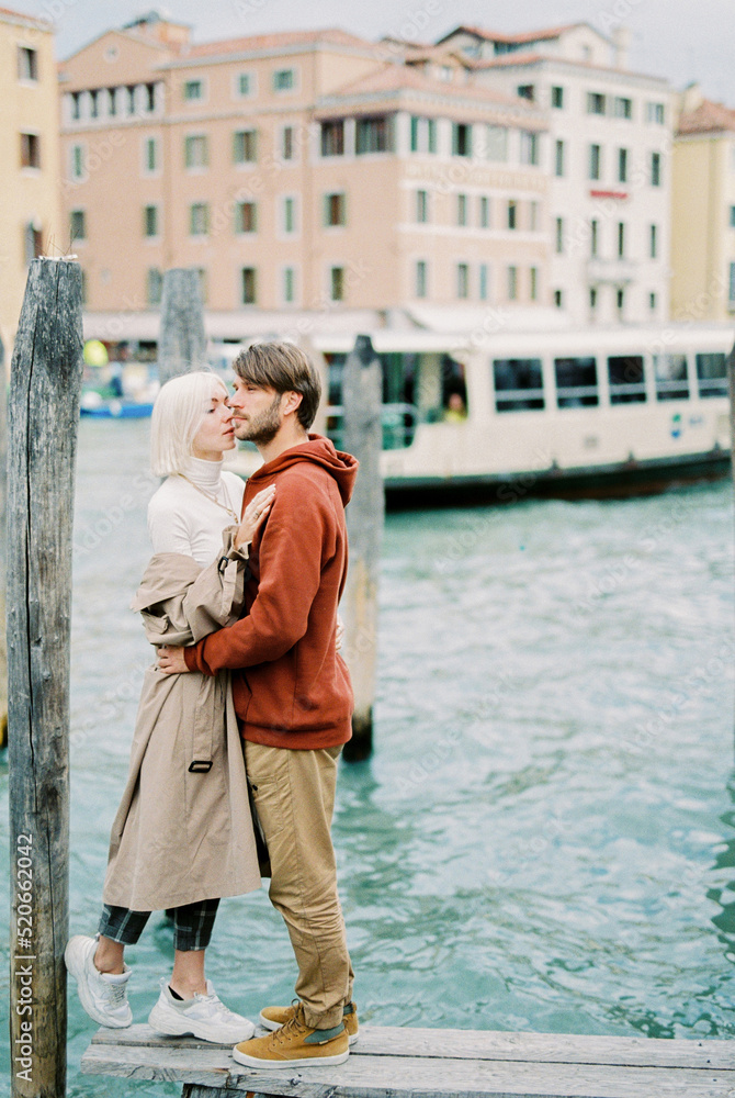 Man hugs woman in front of old houses in Venice