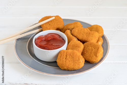 Food background with ketchup for chicken nuggets on gray plate.