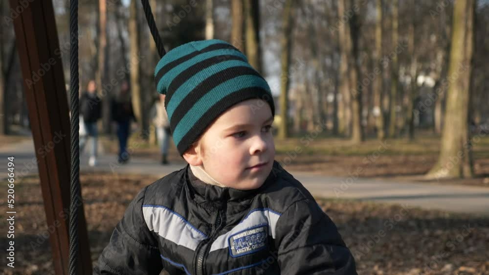 Little Boy Child Swinging on Swing in City Park. Sunny Evening. Slow motion 4K Little Boy Child Swinging on Swing in City Park. Sunny Evening. Slow motion 4K