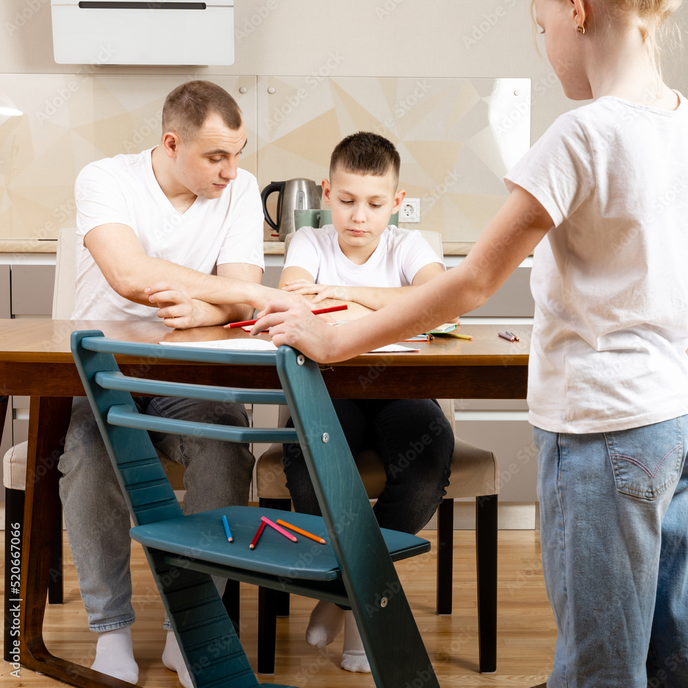 Fototapeta premium learning at home, children in the kitchen studying while the whole family is sitting at the table with them
