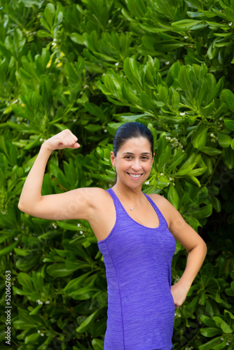 Portrait of female flexing her bicep muscle.
