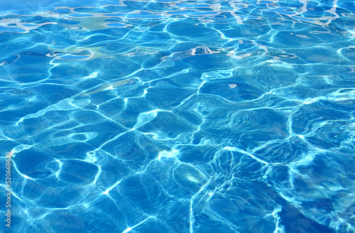 Water background of the pool with the effect of small ripples and sunlight.