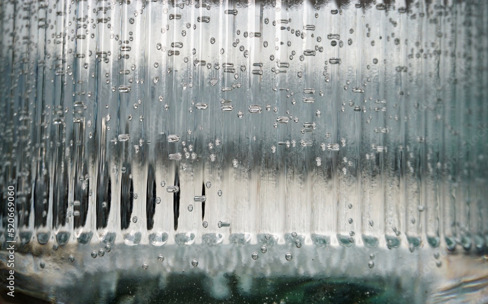 Transparente grau-weiße Glasfassade mit Wassertropfen 