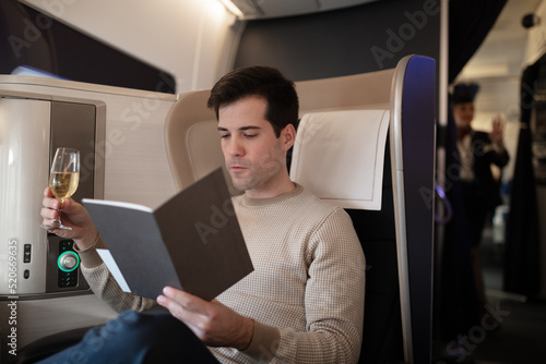 Man being pampered by flight attendants in first class photo