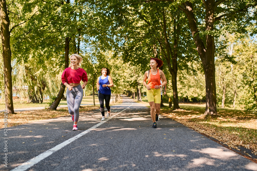 Group of diverse women running together in park