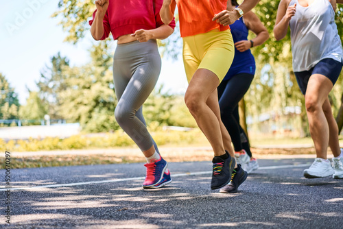 Close-up of group of women jogging together in park