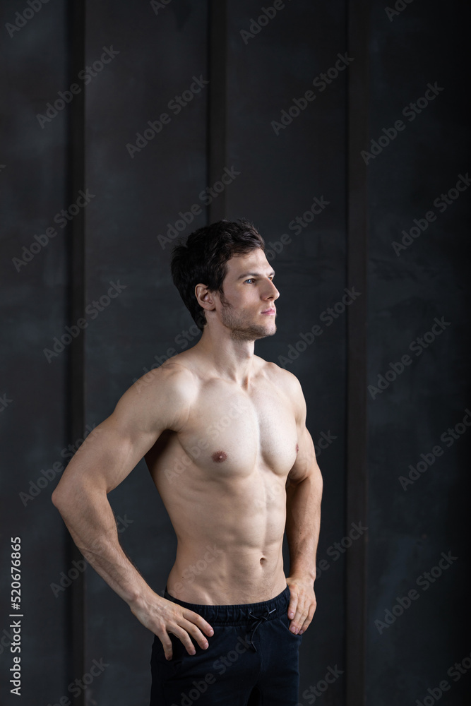 Fototapeta premium Portrait of strong man on dark background. Sport workout