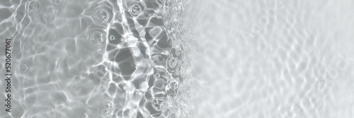 Transparent clear calm water surface texture with waves, splashes and bubbles. Trendy abstract nature background. White grey water waves in sunlight. Caustic effect. Long banner with copy space.