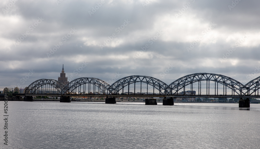 Obraz premium Railway arch bridge under dramatic clouds.