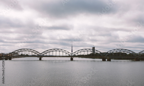 Railway arch bridge under dramatic clouds. © 9parusnikov