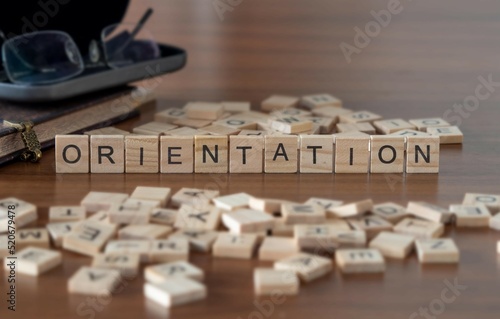 orientation mot ou concept représenté par des carreaux de lettres en bois sur une table en bois avec des lunettes et un livre photo