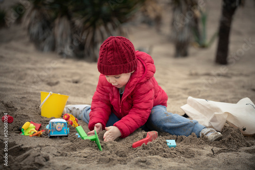 Niño jugando con juguetes en la playa en otoño invierno © Pablo Gazzola