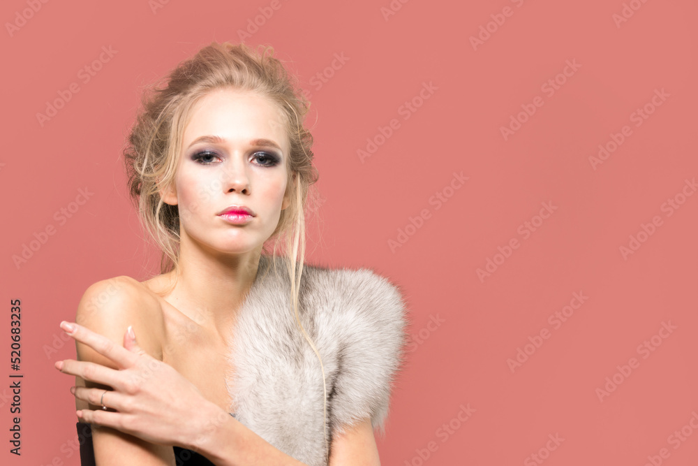 Beautiful girl in a fur cape in the studio close-up on a bright background. Beautiful girl in a fur cape in the studio close-up on a bright background.