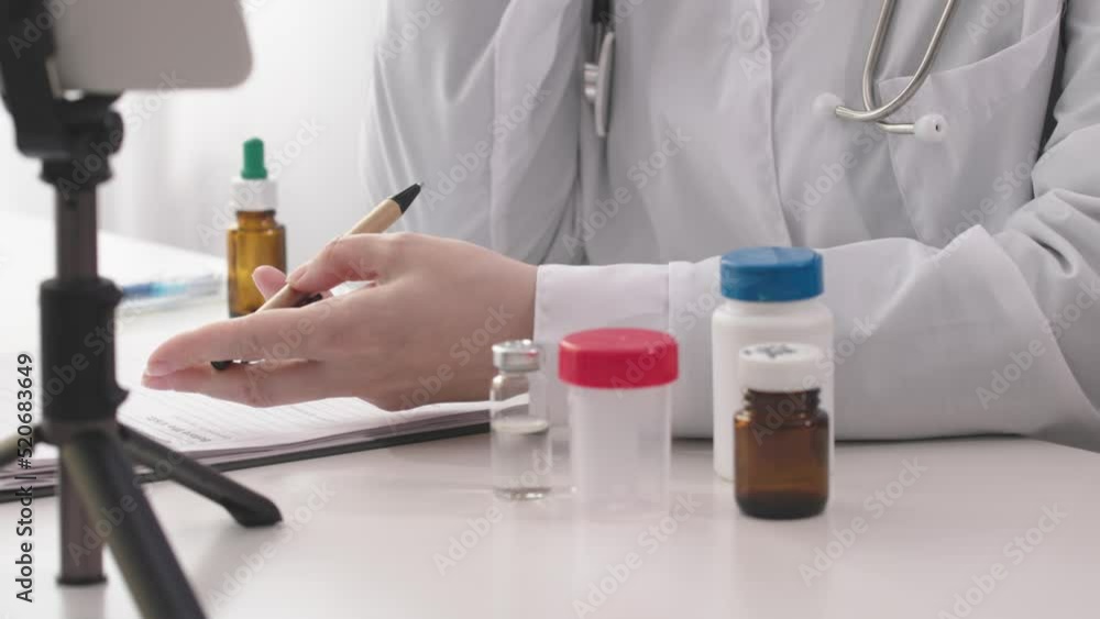 online distant doctor appointment using video call, smartphone, tripod, medicine bottles on doctors desk table, clinic office. welcome conference meeting, discussing, virtual training, medical webinar online distant doctor appointment using video call, smartphone, tripod, medicine bottles on doctors desk table, clinic office. welcome conference meeting, discussing, virtual training, medical webinar