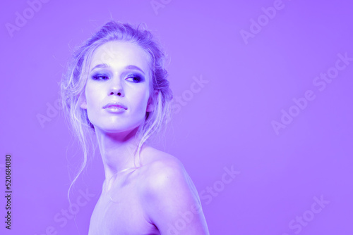 Cute girl model with bare shoulders on a bright background in the studio.