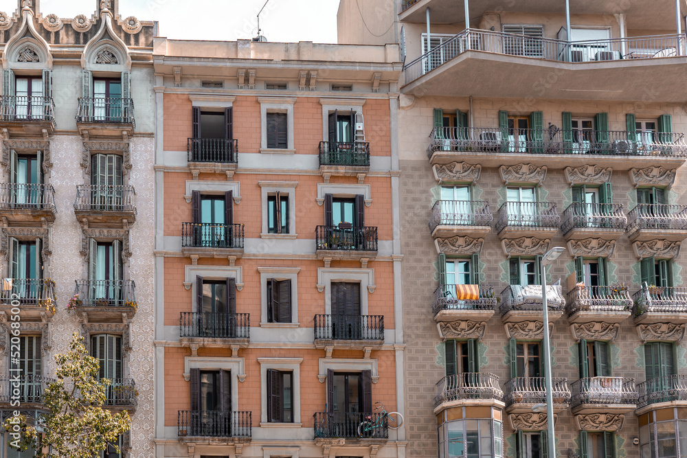 Facade of a typical apartment building in Barcelona, Spain. Exterior building with balconies and window shutters