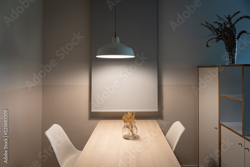 Simple and minimalistic dining area with two chairs, table and lamp © Renata