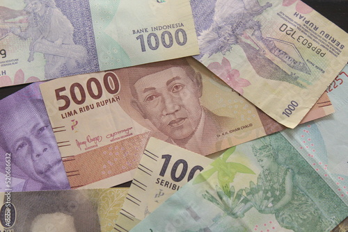 several rupiah bills of various nominals scattered around photo