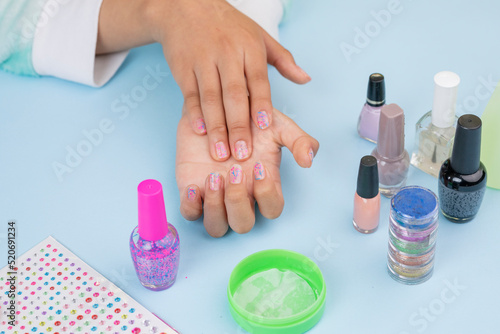 girl's hands, showing nails after painting them, with copy space