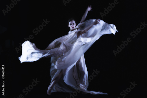 Fototapeta Naklejka Na Ścianę i Meble -  dancer in a white robe on a black background, woman dancing