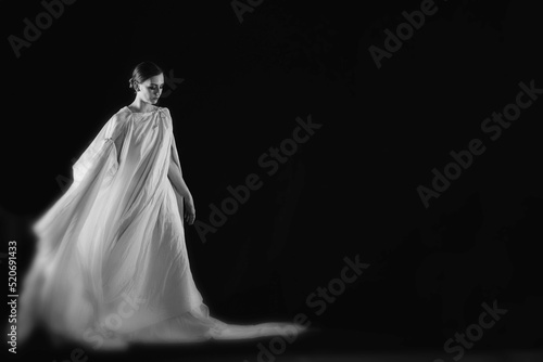 dancer in a white robe on a black background, woman dancing