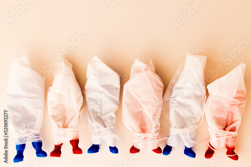 Red and blue Russian toy soldiers in plastic body bags laying in a row. Concept of Russian war casualties