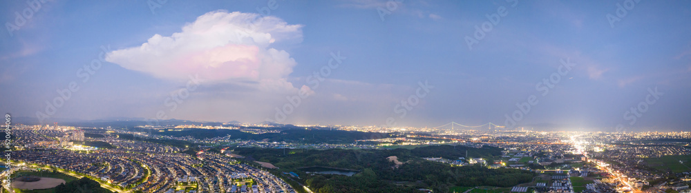 Panoramic view of single cloud over sprawling cityscape at night