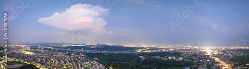 Panoramic view of single cloud over sprawling cityscape at night © Osaze