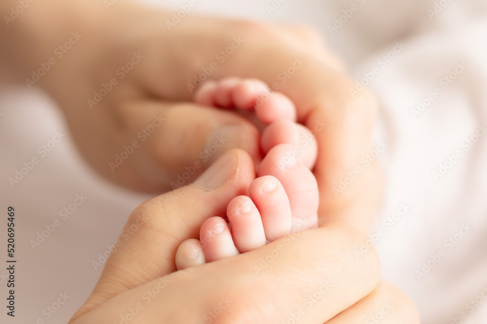 father hand holding baby`s toes