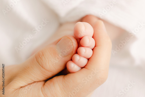 father hand holding baby`s toe © Yuka